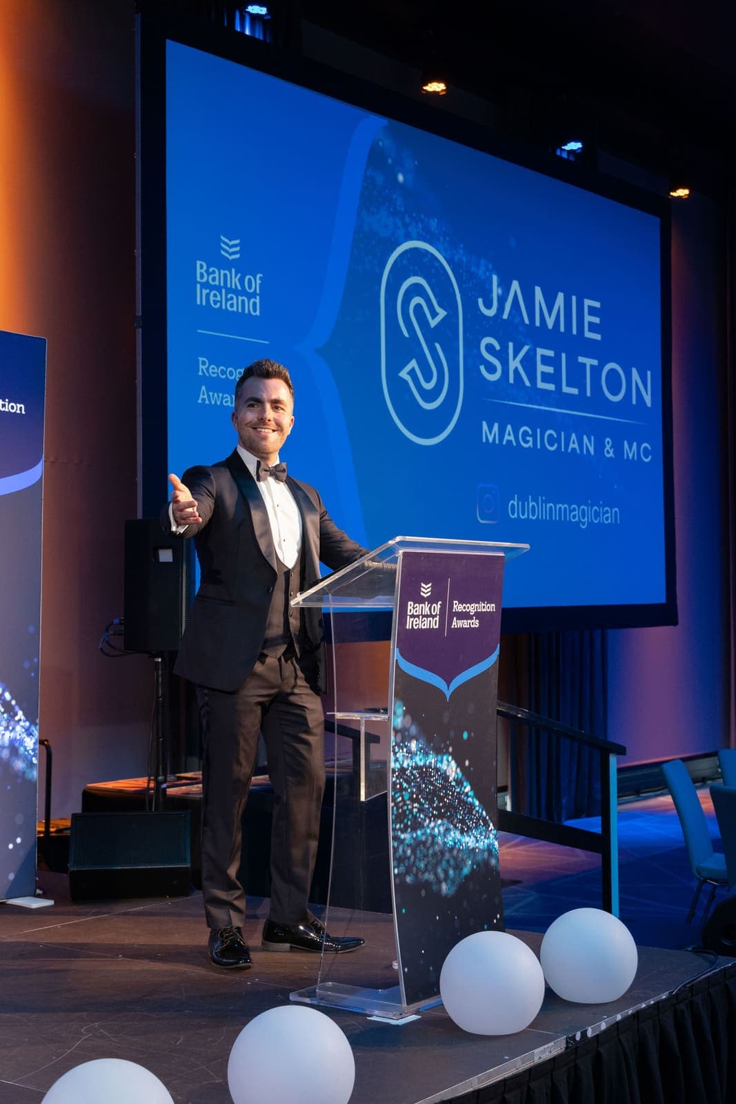 Jamie hosts from the Bank of Ireland Recognition Awards lectern, his name on the big screen behind