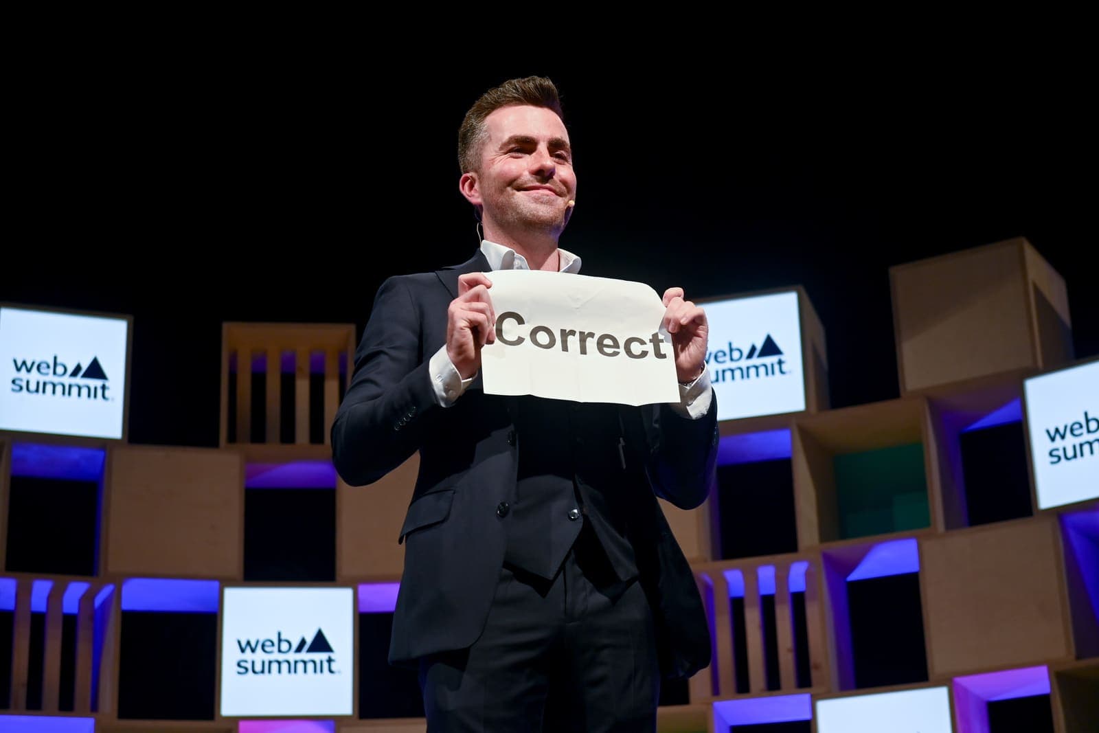 Jamie holds up a card that reads Correct on the Web Summit stage