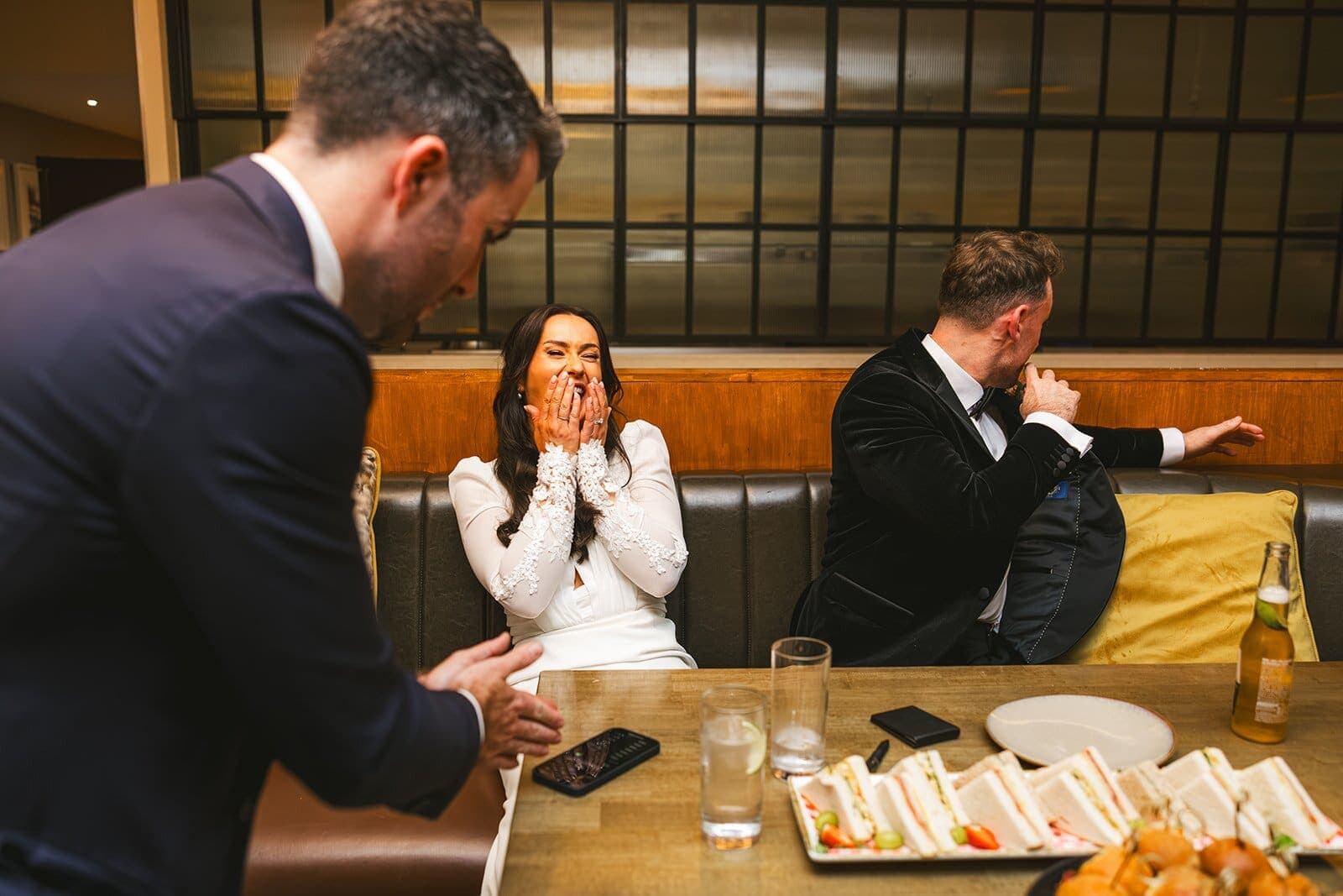 Woman in a bar booth gasps at a trick