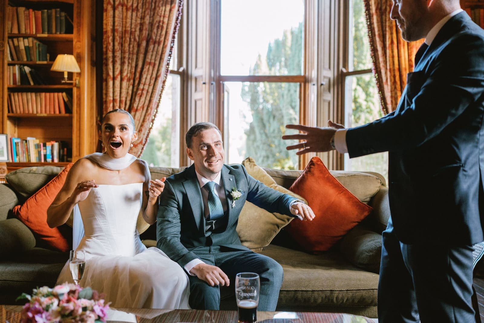Bride and groom in a library room; bride gasps at a trick