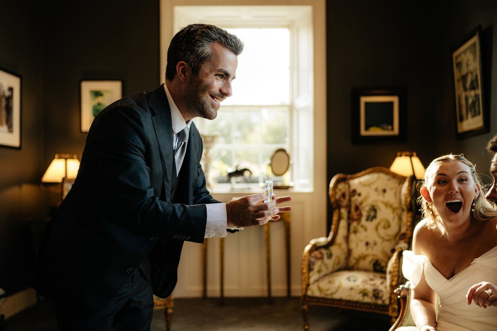 Jamie leans in to perform for a laughing bride in a period drawing room