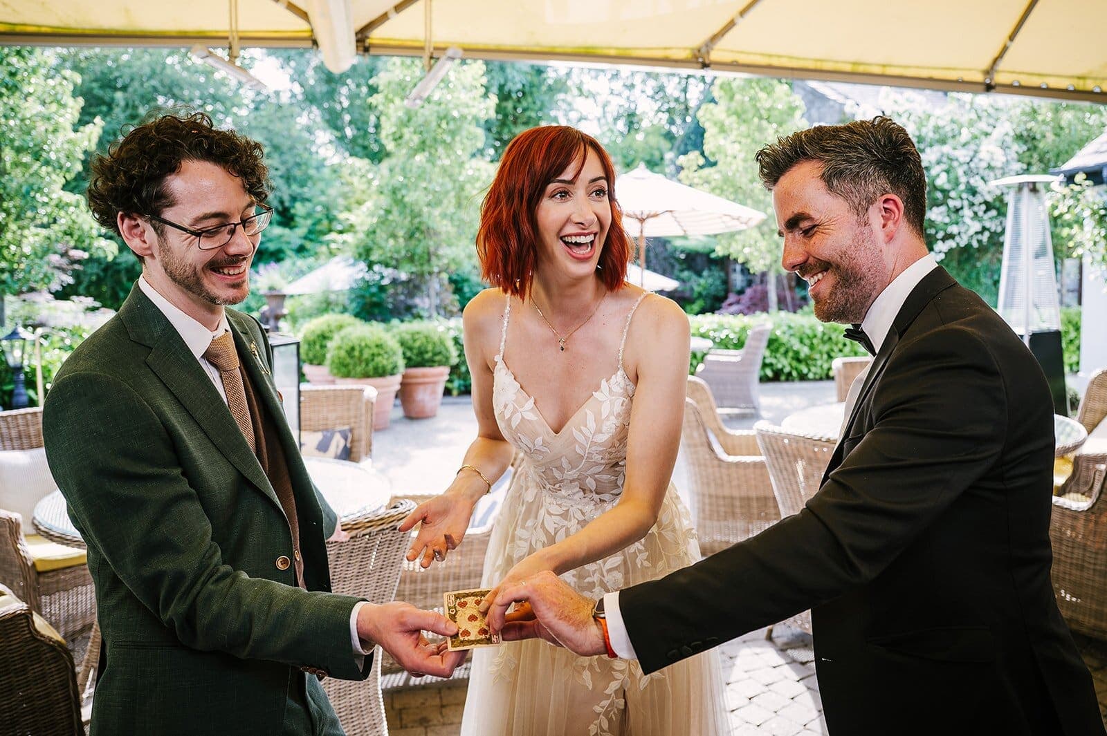 Bride and guest on an outdoor terrace; Jamie hands over a card