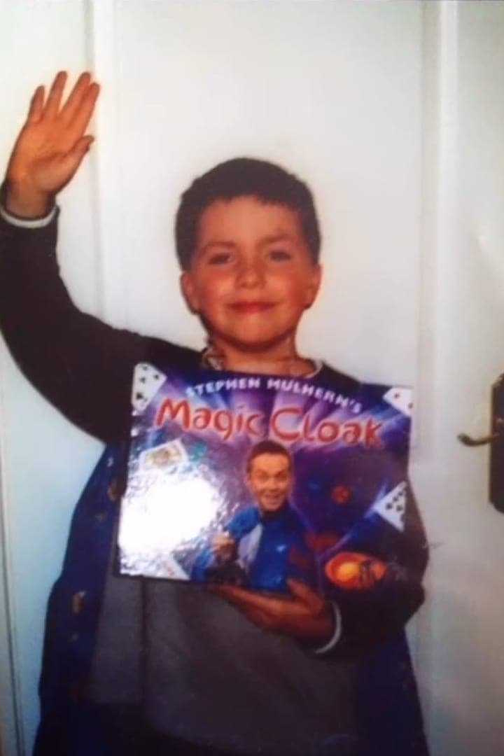 A young Jamie waves and holds a Stephen Mulhern Magic Cloak set