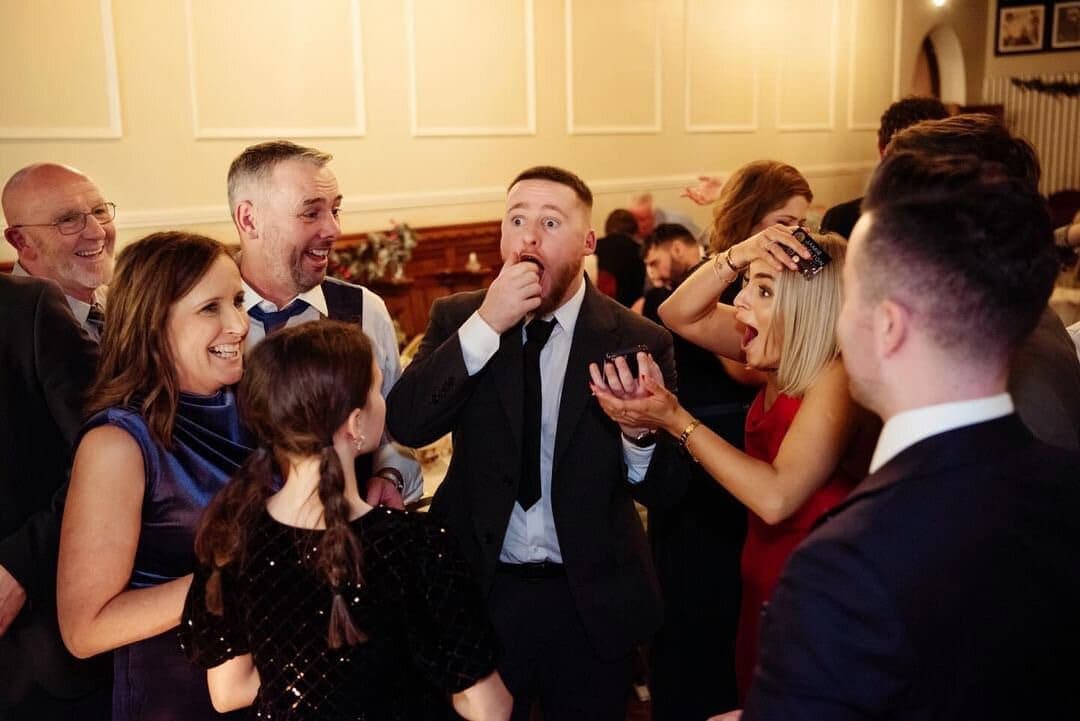 Guests at an evening event cover mouths in shock during close-up magic
