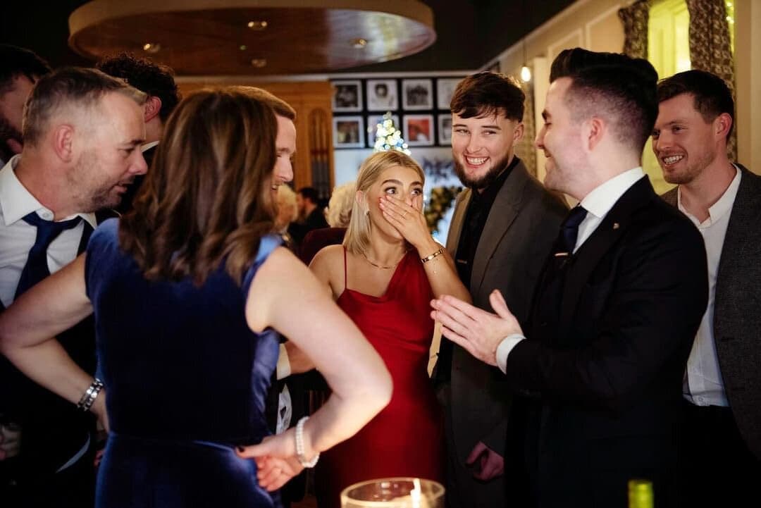 Guests at a private party react with surprise to a trick