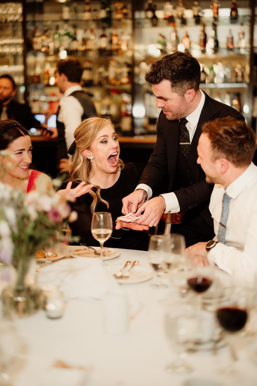 In a restaurant, a guest gasps open-mouthed as Jamie does a trick on the table