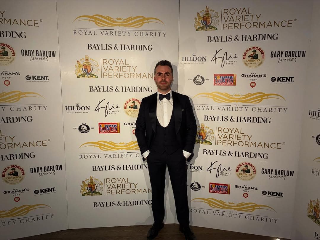 Jamie in black tie in front of a Royal Variety Performance and Royal Variety Charity backdrop