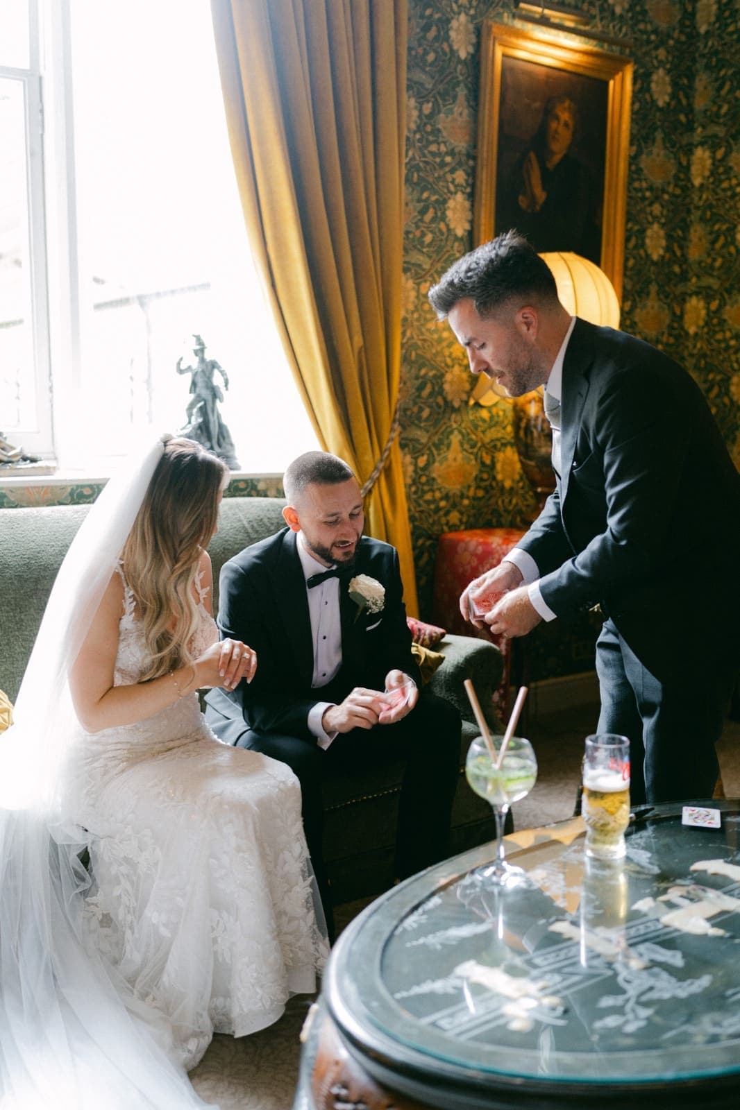 Jamie leans over to deal cards into Luke's hands as Amy watches