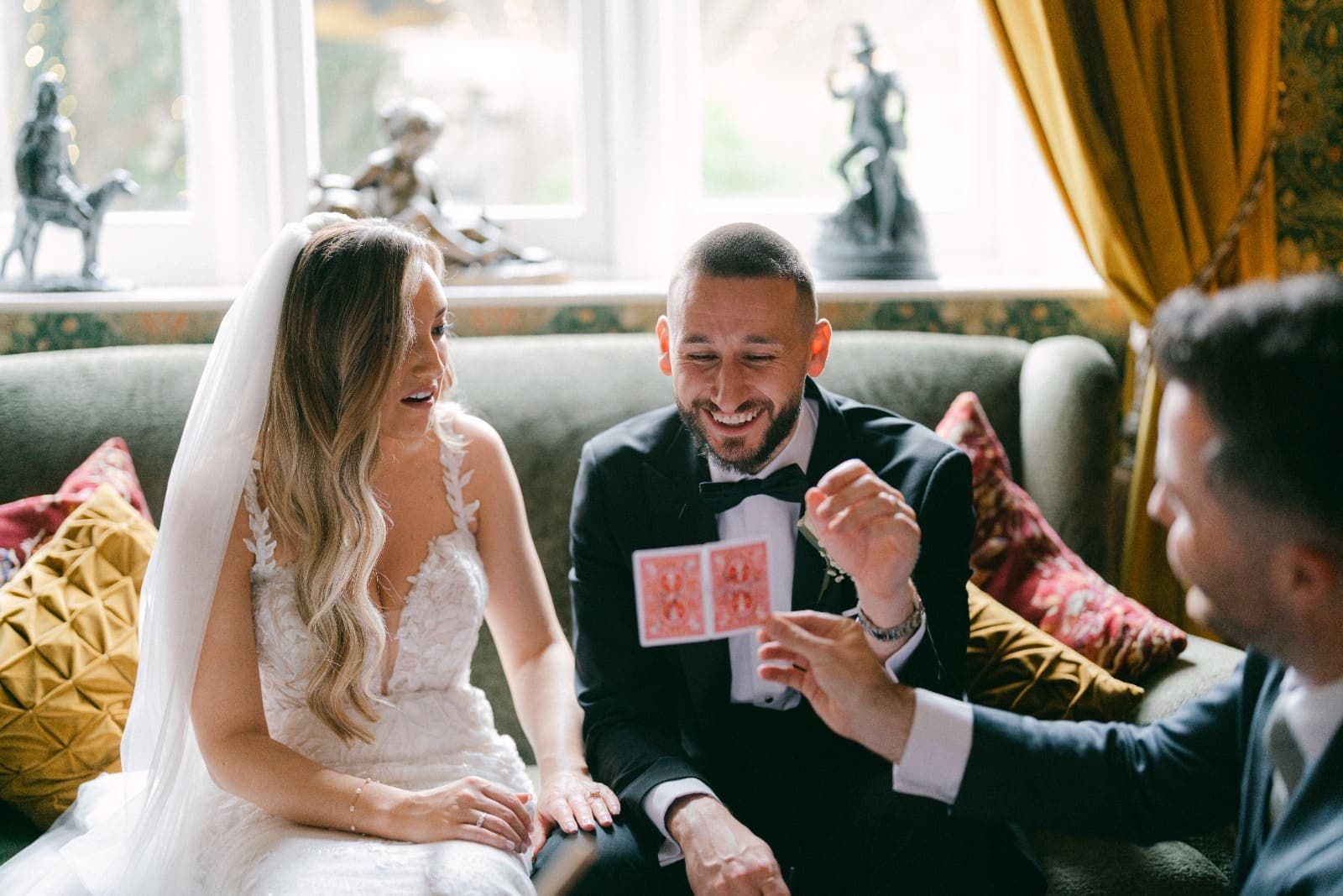 At Cabra Castle, Luke laughs and Amy's mouth falls open as Jamie holds up two red-backed playing cards