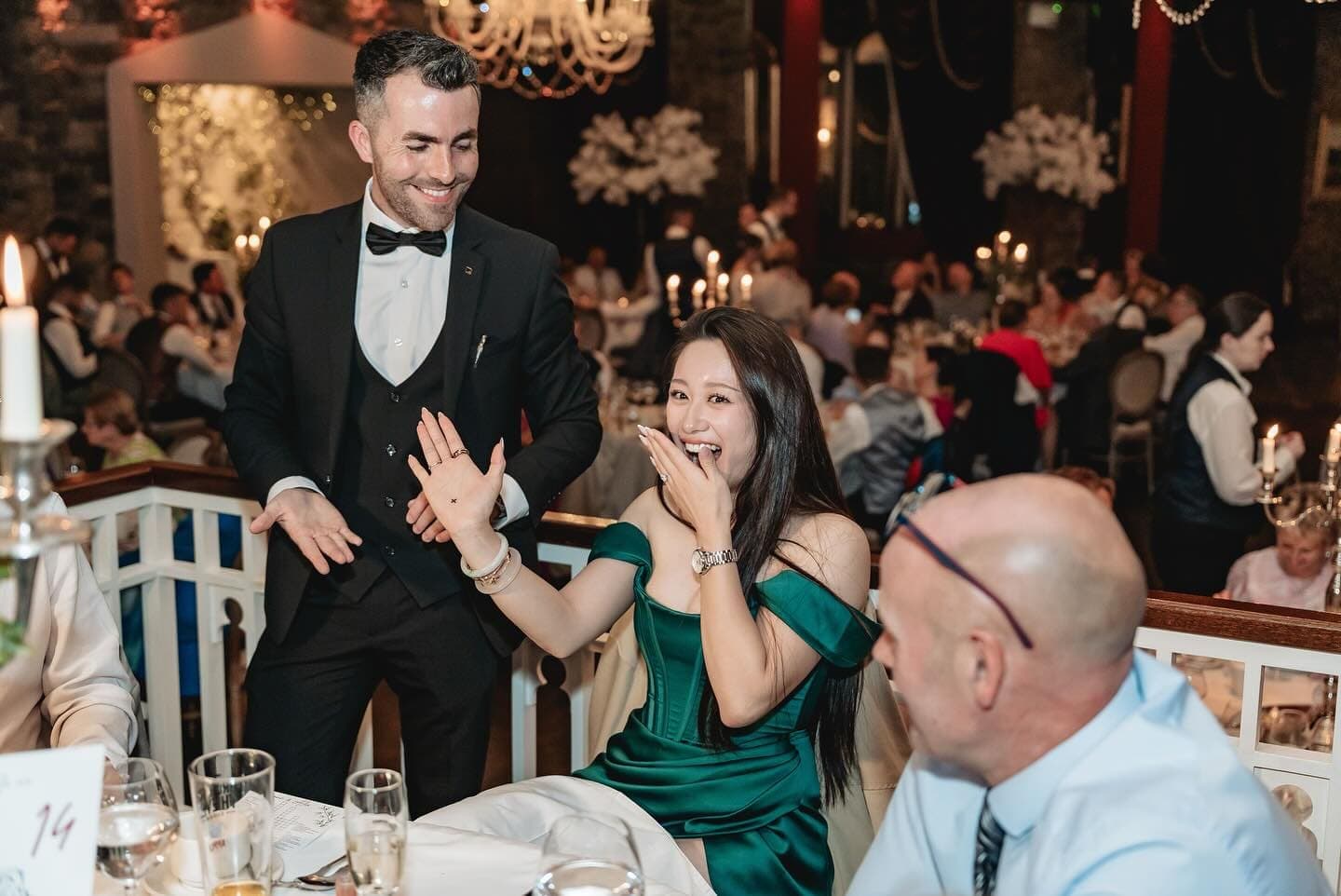 At Alex and Suzanne's wedding at Cabra Castle, a guest in green gasps with her hand up as Jamie stands over her, smiling