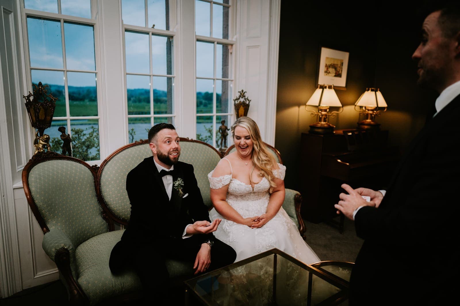 Oisin holds out his hand as Janice laughs at Jamie's card trick on the sofa
