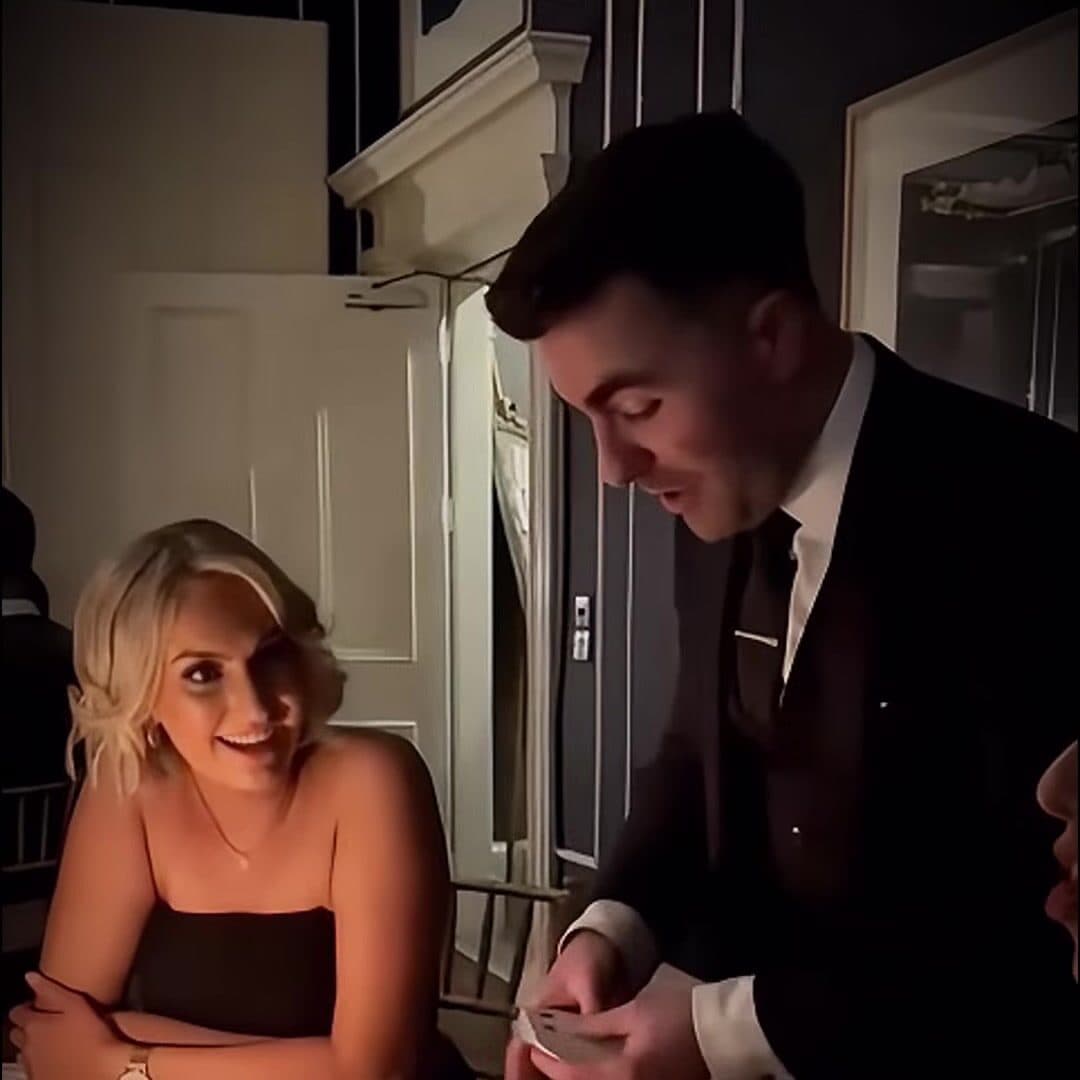 A guest smiles as Jamie deals the cards in front of her