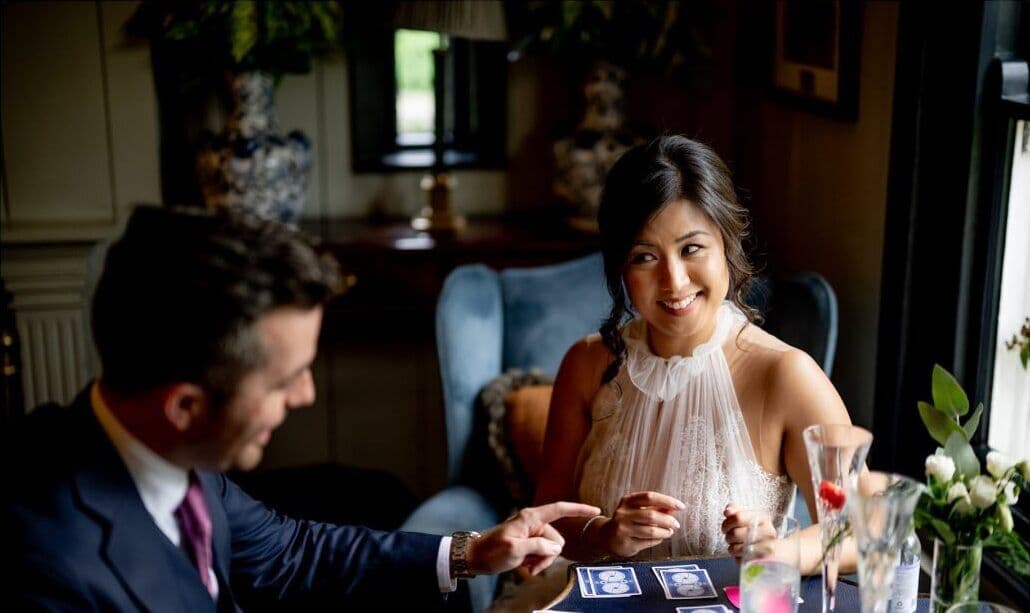Fiona smiles as Jamie points to the cards on the library table