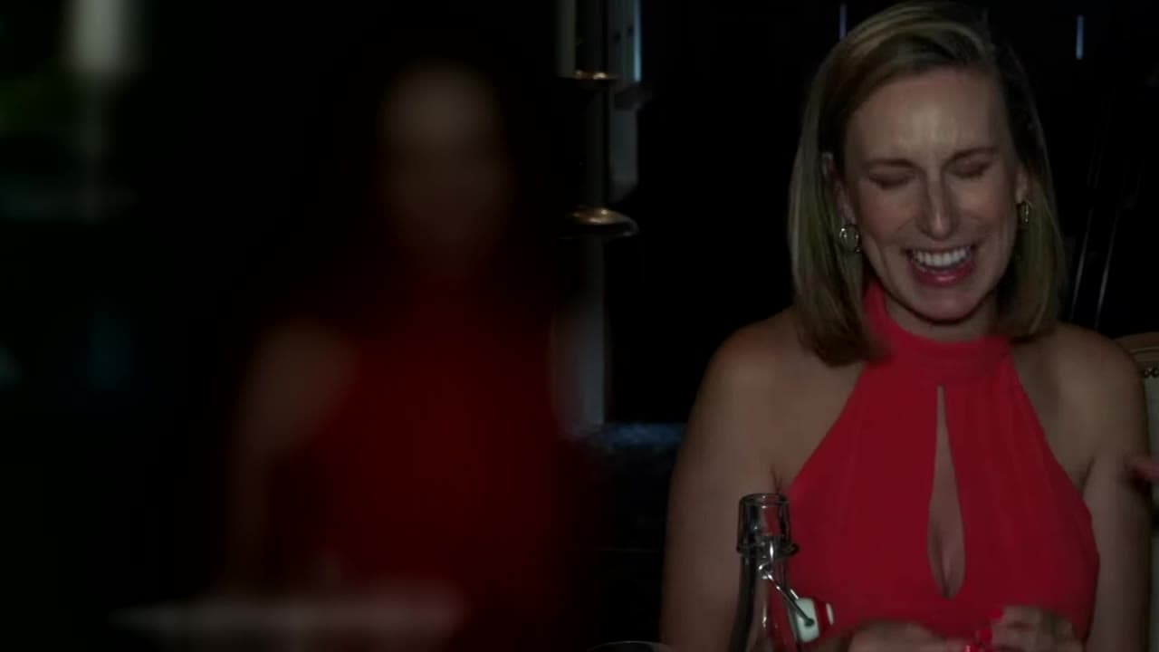 A wedding guest in a red dress laughs out loud at Jamie's magic at Cabra Castle
